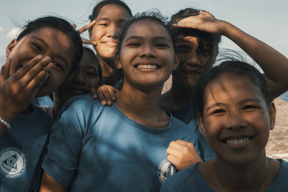 A group of young friends smiling and enjoying a sunny day outdoors, showcasing joy and friendship.
